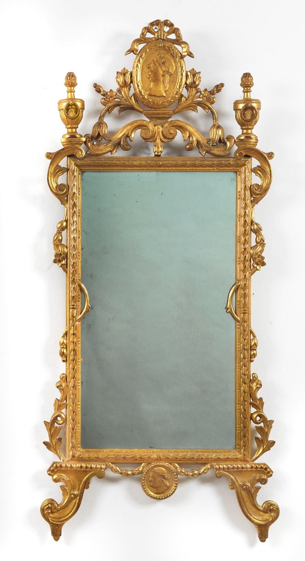 Mirror in gilded wood and richly carved with Empire motifs