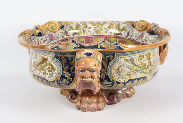 Grande vasca in maiolica lustrata Gualdo Tadino, marcata Alfredo Santarelli (1874-1957), interamente variopinta con scene mitologiche, draghi, mascheroni e cariatidi. Anni '30- '40