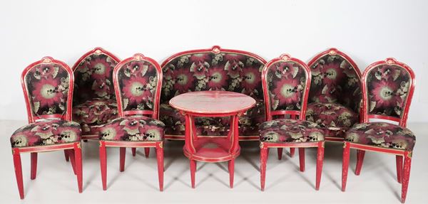 French Liberty living room in red lacquered wood with gold profiles: sofa, two armchairs, four chairs and round table with chinoiserie decorated top (8 pcs.). Very damaged floral fabric covering