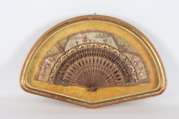 Ventaglio decorato a motivi di paesaggi e volute, cornice a bacheca in legno dorato