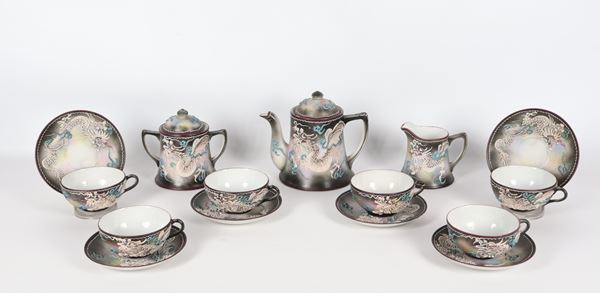 Servizio da tè giapponese in porcellana Epoca Liberty, con decorazioni policrome a rilievo di draghi: teiera, lattiera, zuccheriera e sei tazze con piattini (9 pz.). Il manico di una tazza è rincollato e il bordo della teiera presenta due lievi sbeccature