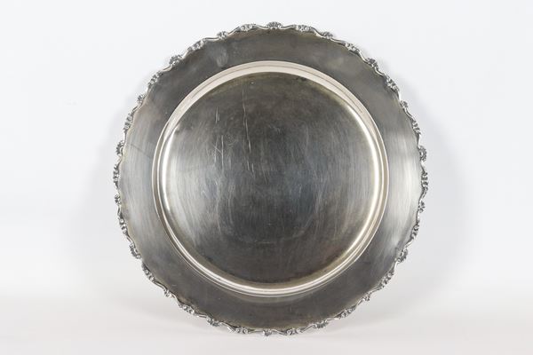 Piatto tondo in argento, con bordo cesellato e sbalzato a motivi di volute e conchiglie, gr. 575