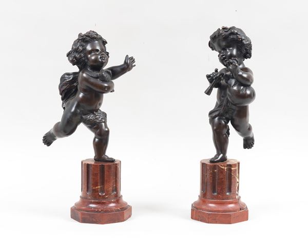 &quot;Putti suonatori&quot;, a pair of ancient sculptures in patinated and embossed bronze, supported by bases in the shape of fluted columns in veined red marble. Late 18th century 