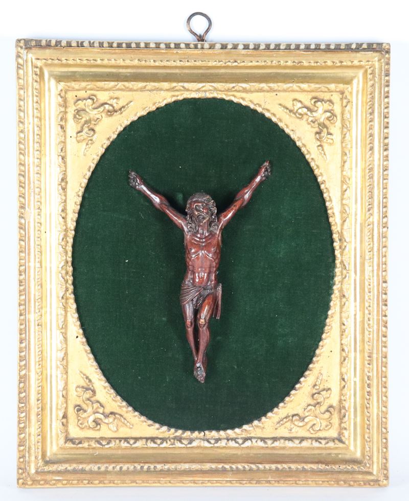 Antico piccolo Cristo in legno di bosso intagliato e patinato, montato su pannello in velluto ver...