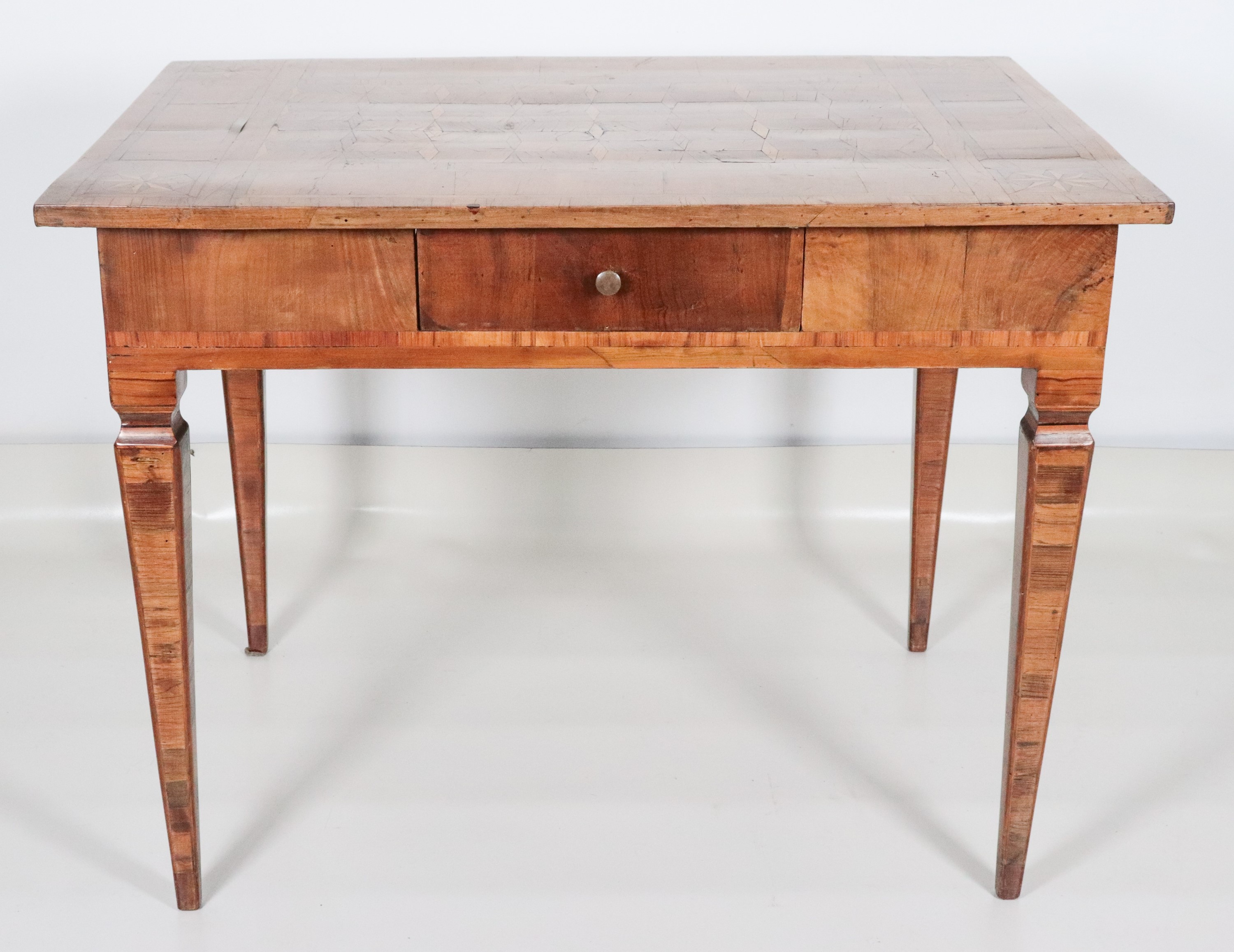 Antico tavolo da centro veneto Luigi XVI in noce e ulivo, a forma rettangolare con piano intarsia...