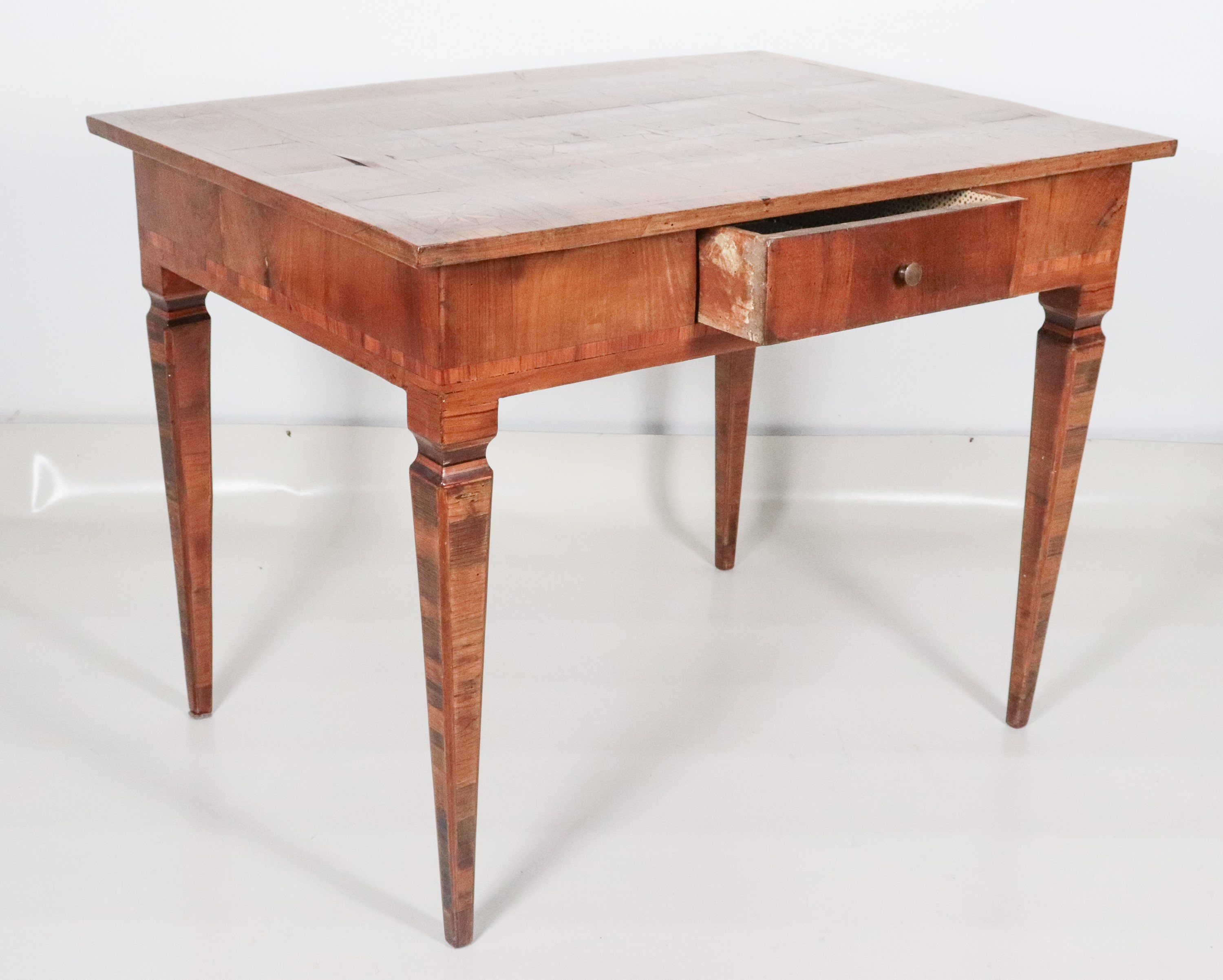 Antico tavolo da centro veneto Luigi XVI in noce e ulivo, a forma rettangolare con piano intarsia...