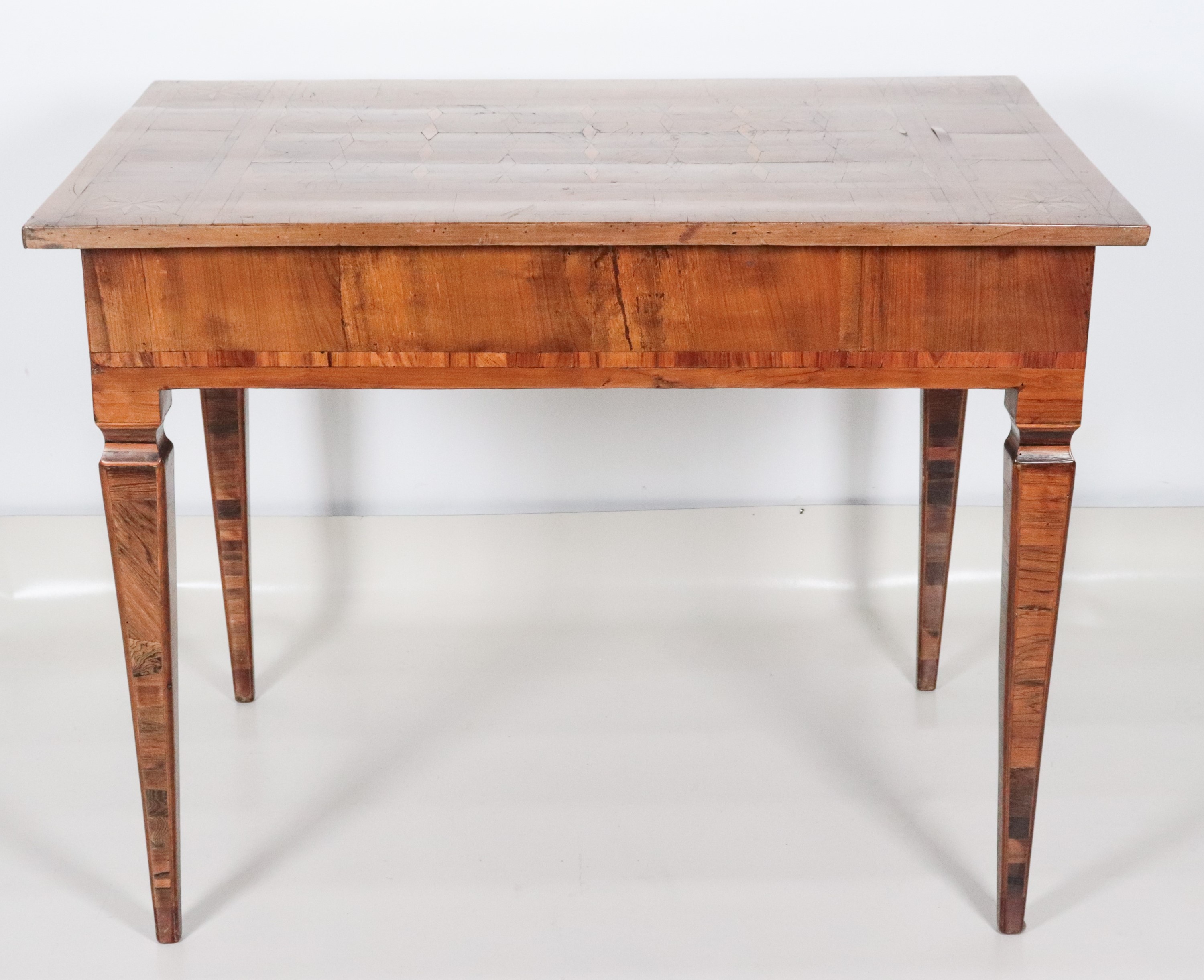 Antico tavolo da centro veneto Luigi XVI in noce e ulivo, a forma rettangolare con piano intarsia...