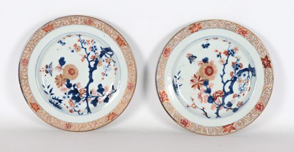 Coppia di antichi piatti cinesi Imari da muro in porcellana, interamente decorati con smalti policromi a rilievo a motivi di alberi, foglie e fiori esotici