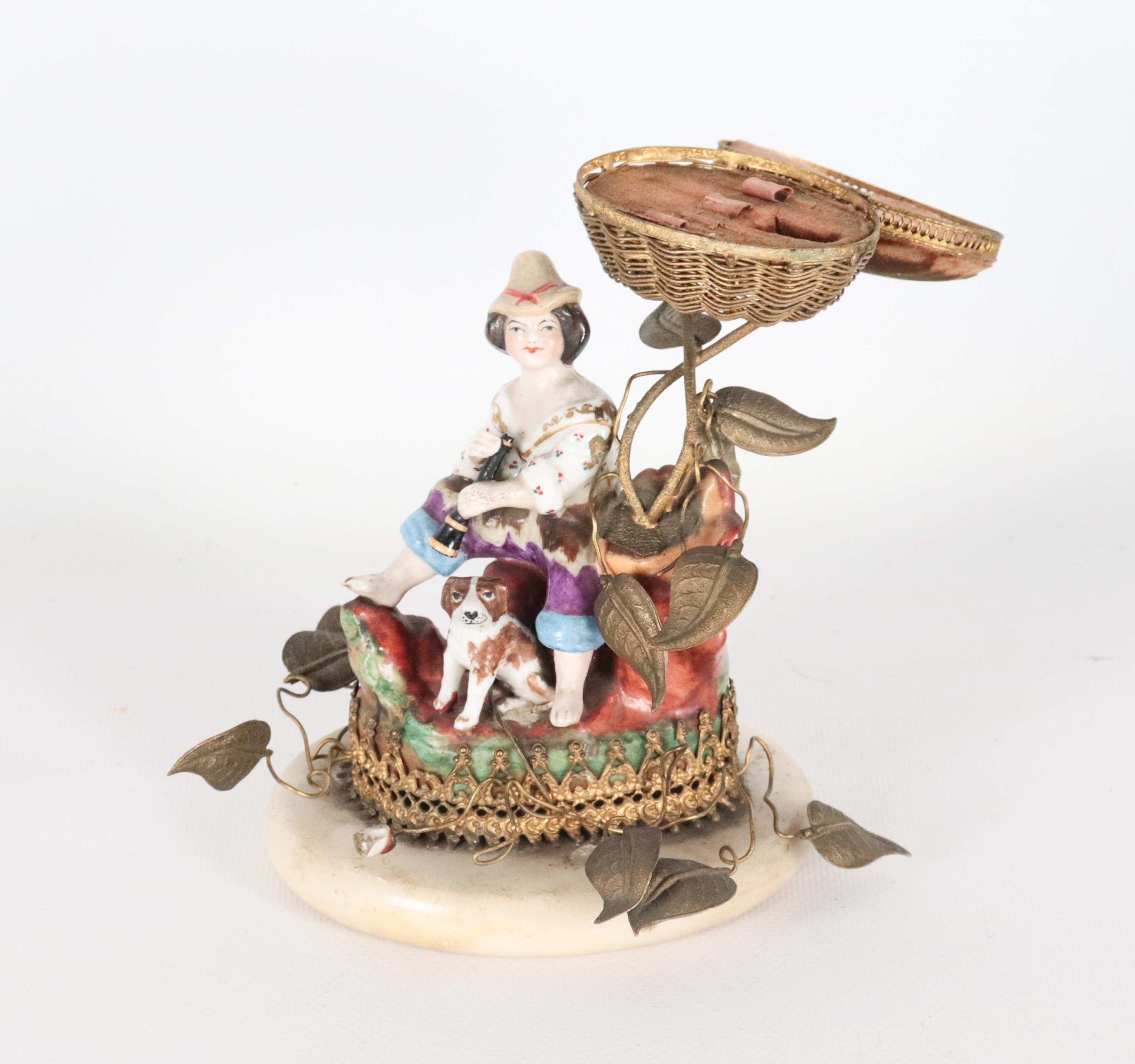 "Pastorello con cagnolino e cesto", antico piccolo gruppo in porcellana policroma e metallo dorat...