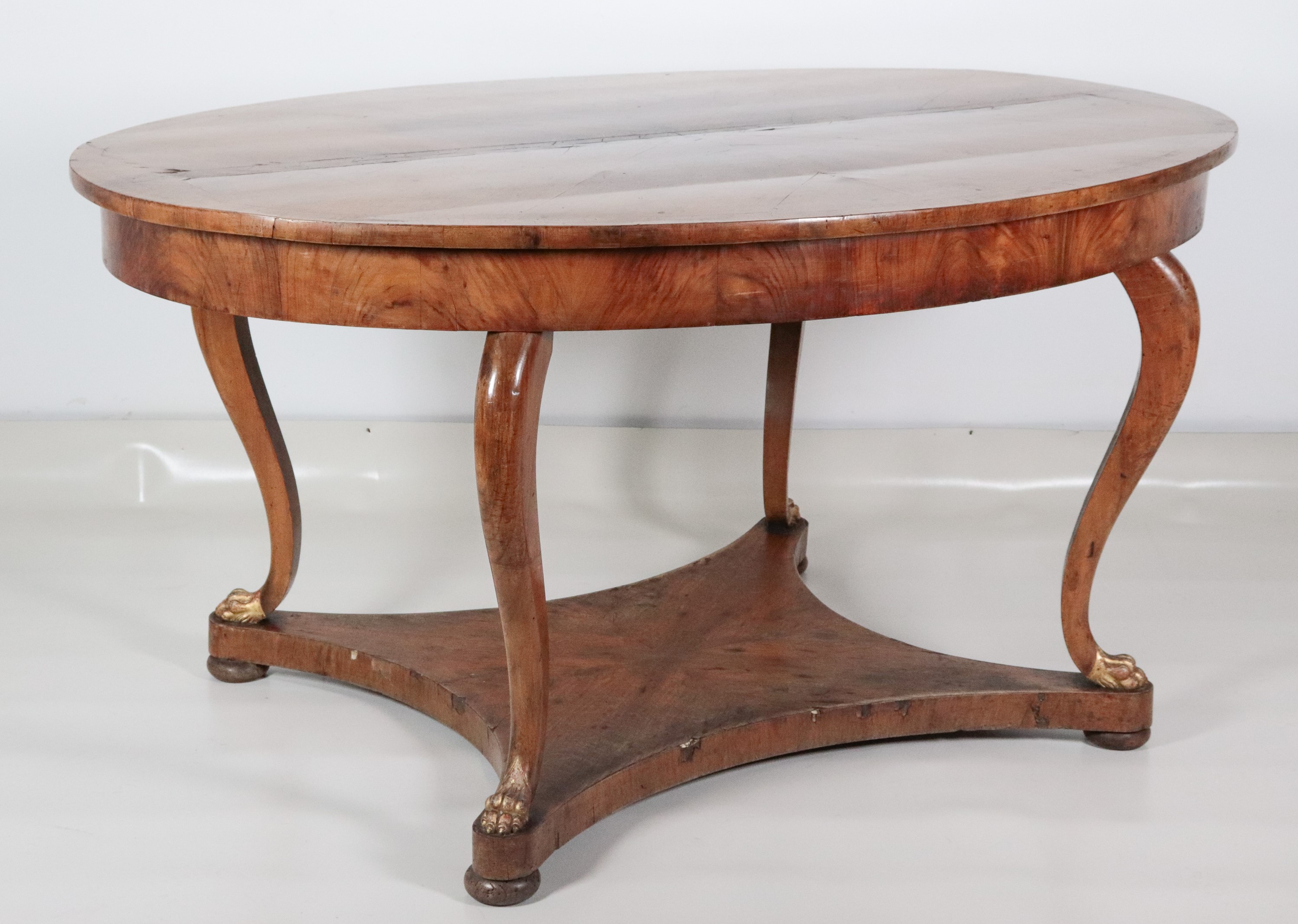 Antico tavolo da pranzo toscano Impero in noce, a forma ovale, con quattro gambe ricurve terminan...
