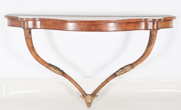 Antica consolle da muro toscana Impero in noce, a forma semitonda centinata con due gambe ricurve e fregi in legno dorato e intagliato