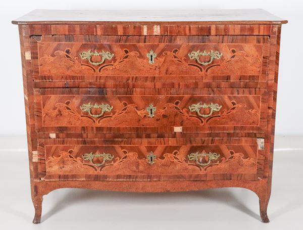 Antico cassettone veneto Luigi XV in noce, con intarsi in bosso a volute floreali intrecciate, tre tiretti, maniglie e bocchette in bronzo dorato e gambe ricurve. Vari difetti e mancanze