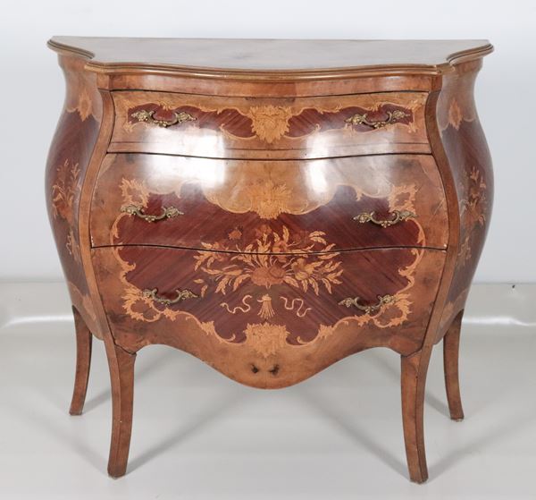 Comò bombato di linea Luigi XV, in bois de rose, ebano viola e legno satinato, con intarsi a motivi di mazzi di fiori e volute intrecciate, tre tiretti e quattro gambe ricurve 