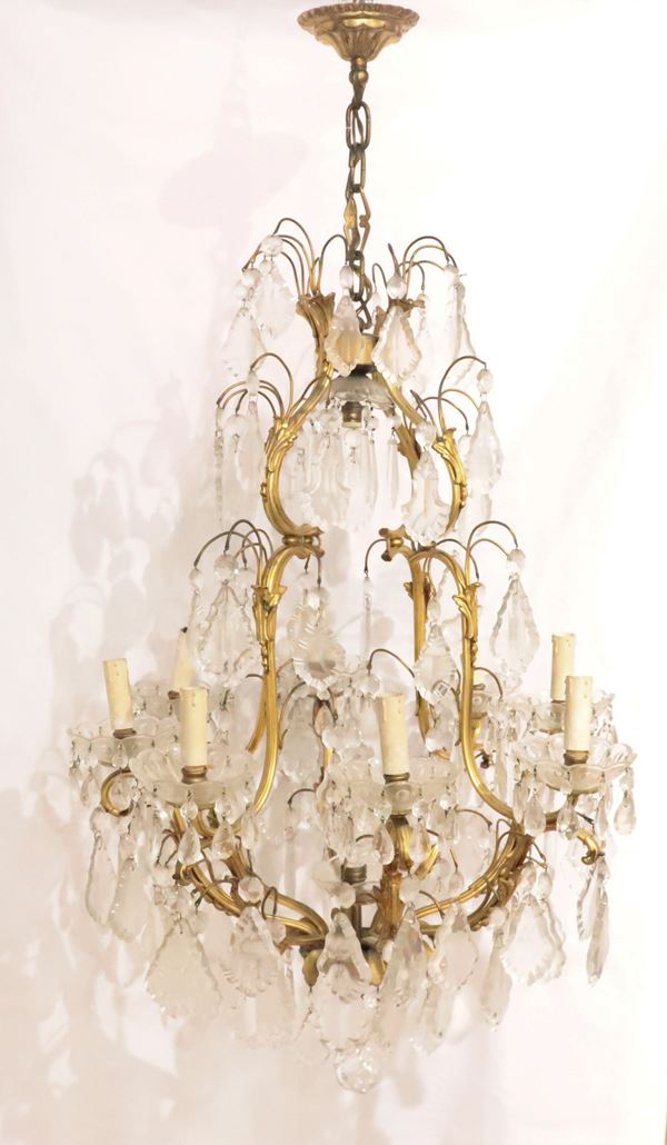 Lampadario francese di linea Luigi XV,  in bronzo dorato e cesellato con prismi in cristallo lavorato, 9 luci