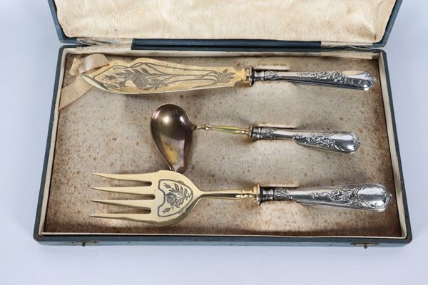 Lotto di tre posate da portata con manici rivestiti in argento cesellato e sbalzato e vermeil, annesso astuccio (3 pz.)