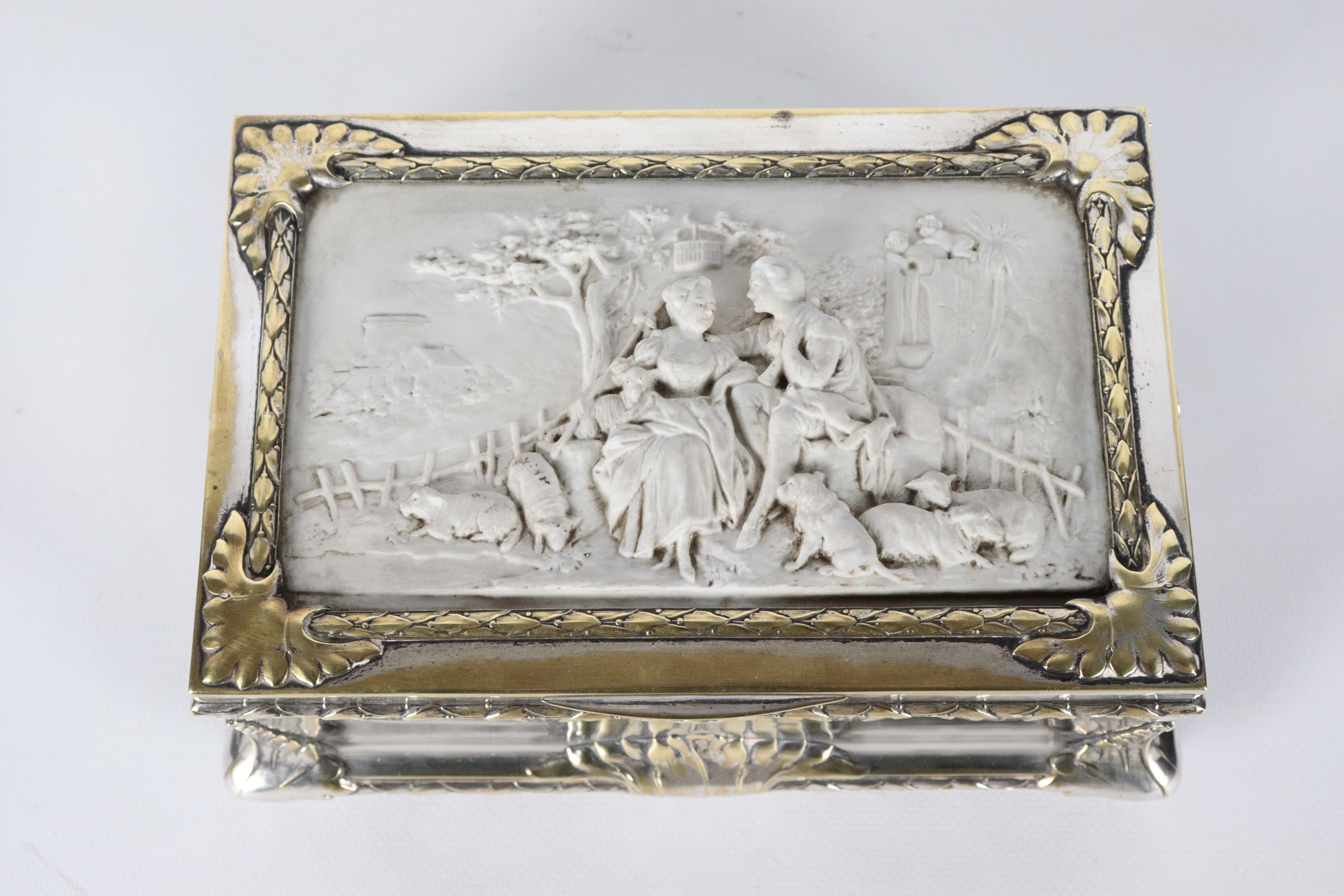 Antico scrigno in metallo argentato, sbalzato e cesellato, sul coperchio placca in biscuit bianco...