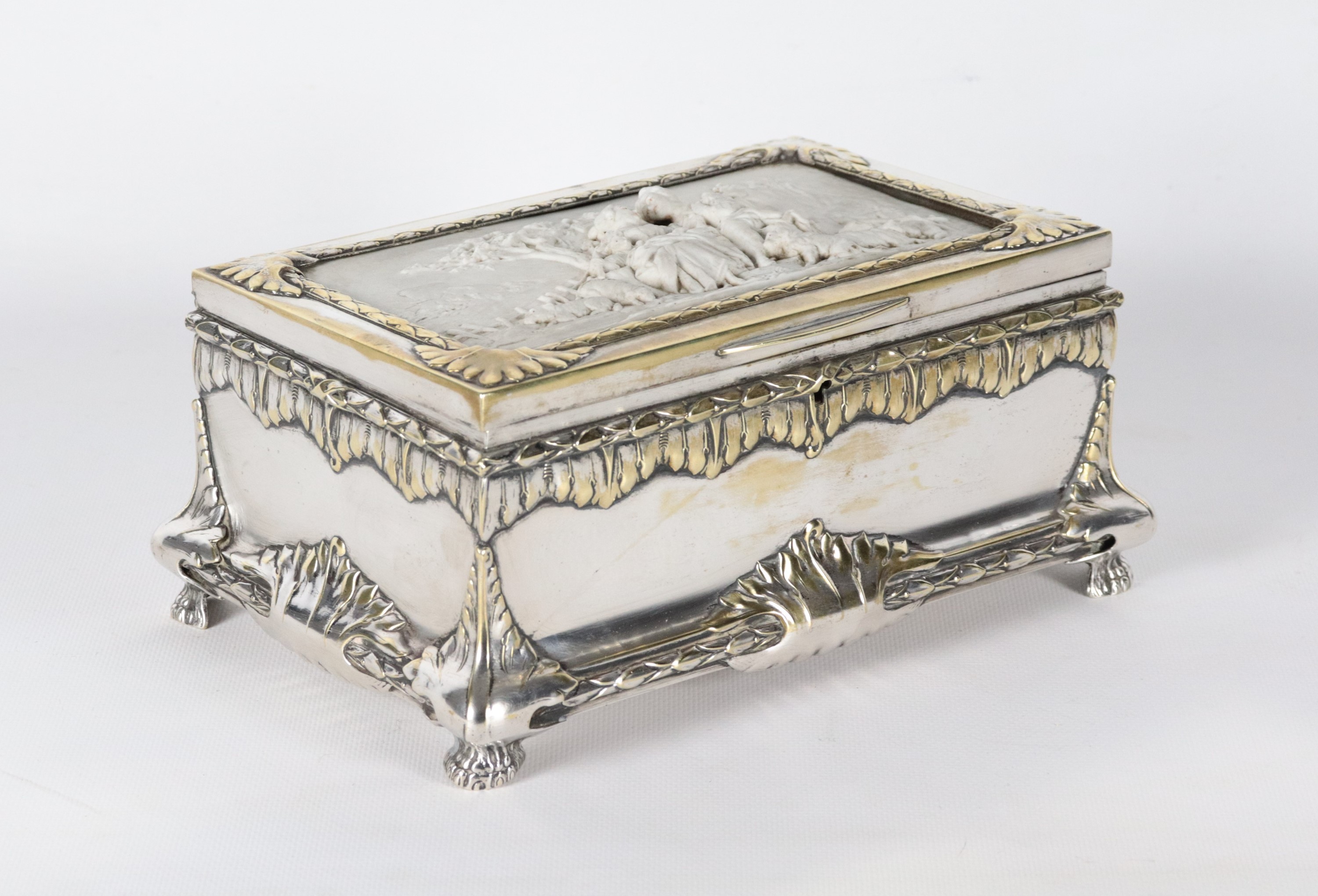 Antico scrigno in metallo argentato, sbalzato e cesellato, sul coperchio placca in biscuit bianco...
