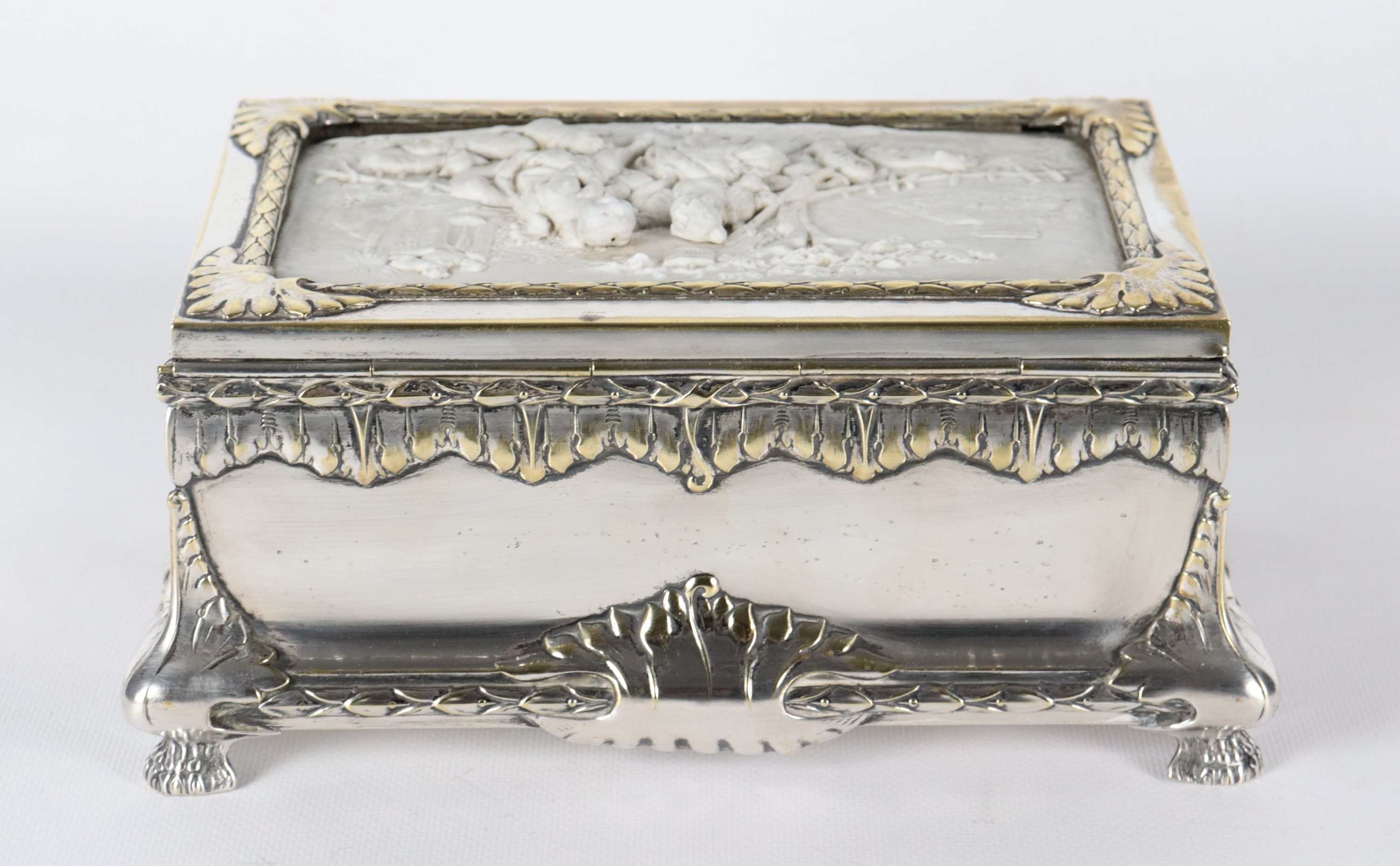 Antico scrigno in metallo argentato, sbalzato e cesellato, sul coperchio placca in biscuit bianco...