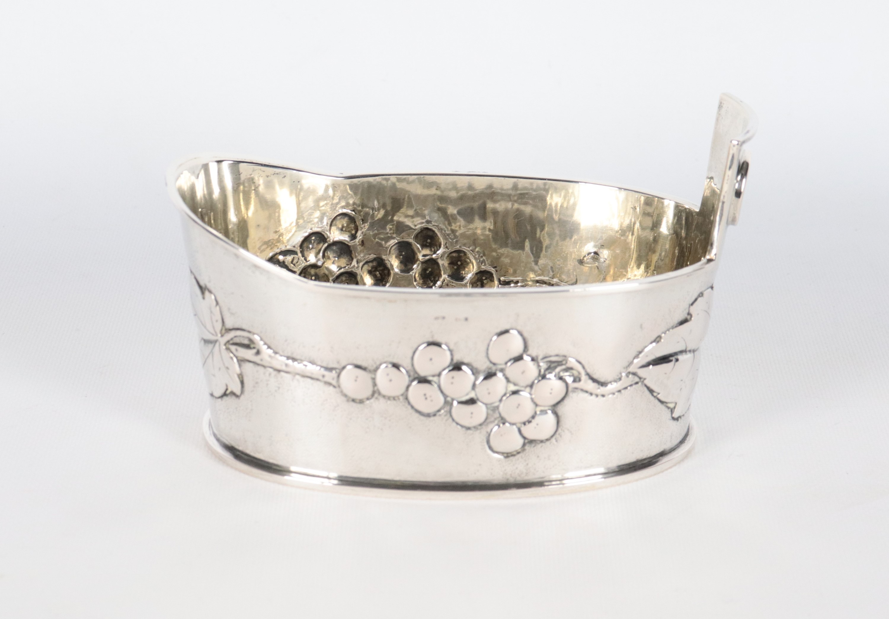 Piccolo versatoio ovale in argento cesellato e sbalzato a rilievo a motivi di grappoli d'uva, gr....