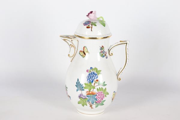 Caffettiera in porcellana bianca di Herend, con decorazioni variopinte a rilievo a motivi di mazzetti di fiori e farfalle, lumeggiature in oro zecchino