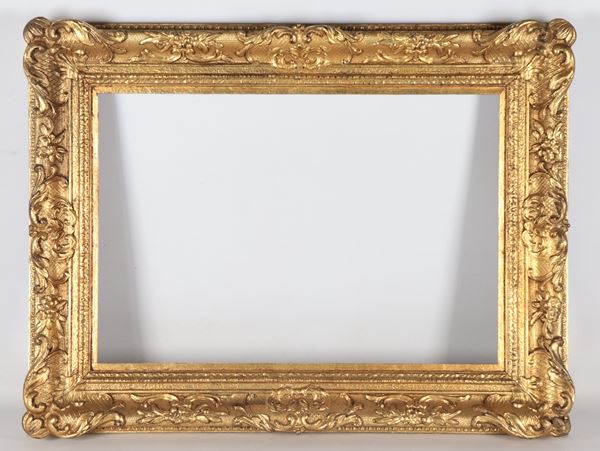 Antica cornice francese in legno dorato e intagliato a motivi di volute e intrecci floreali