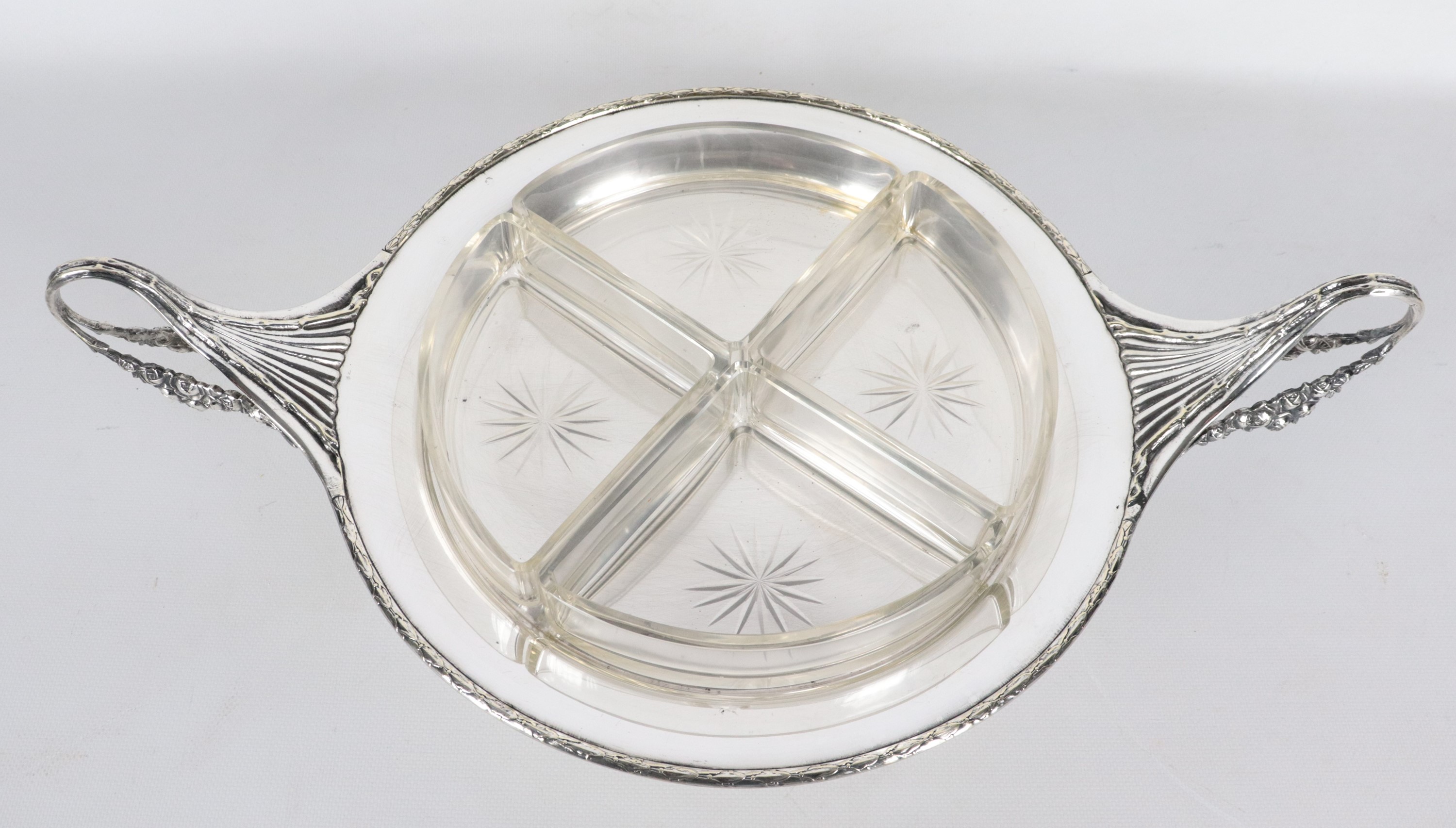 Antica antipastiera a forma tonda in metallo argentato, sbalzato e cesellato con due manici ricur...