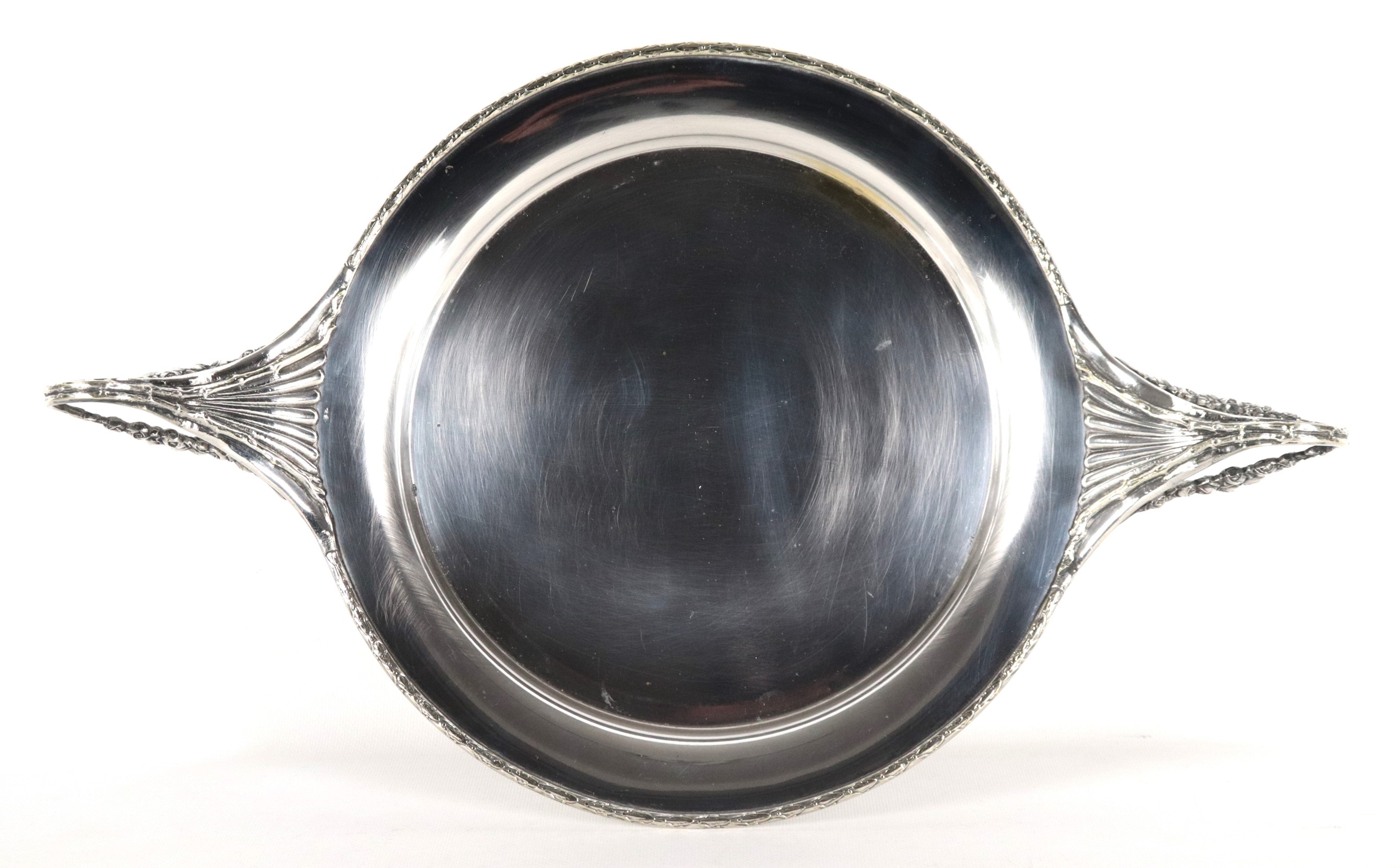 Antica antipastiera a forma tonda in metallo argentato, sbalzato e cesellato con due manici ricur...