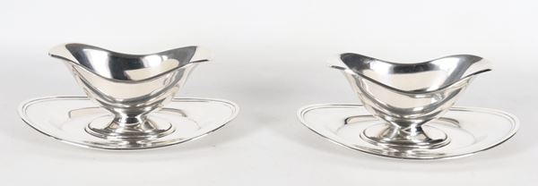 Pair of silver metal sauce boats with placemats