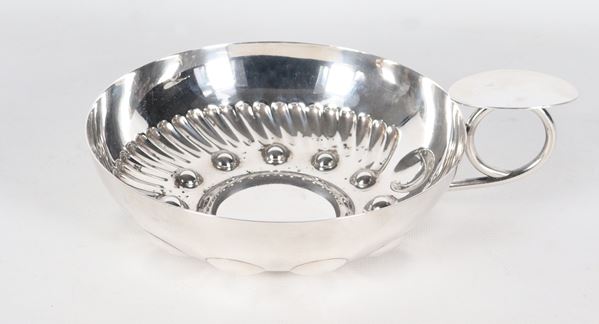 Silver metal bowl with curved handle
