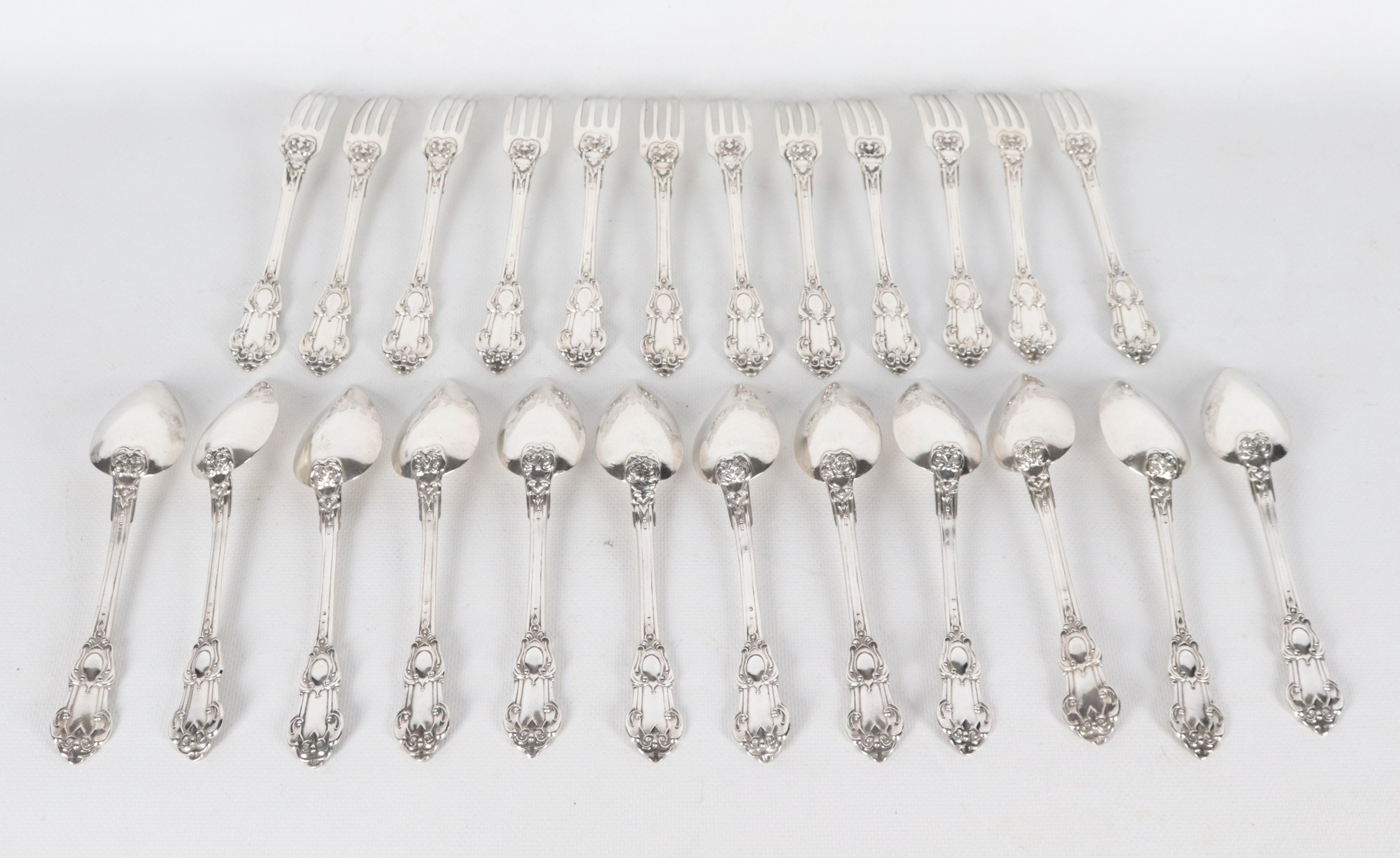 Lotto di dodici cucchiai e dodici forchette in argento sbalzato (24 pz), gr. 680