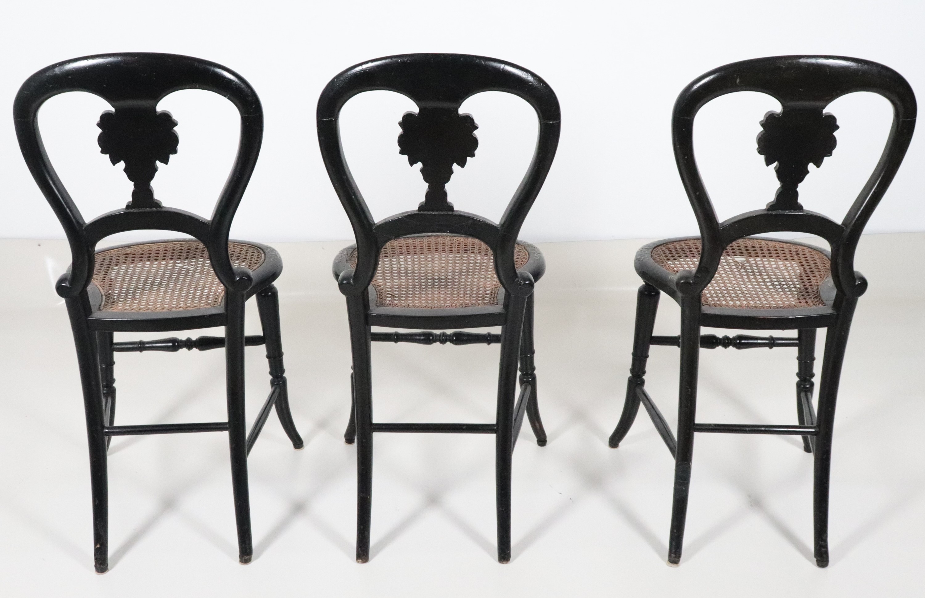 Lotto di tre sedie in legno ebanizzato con intarsi e applicazioni in madreperla