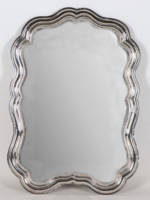 Antique shaped mirror in chiseled and embossed silver