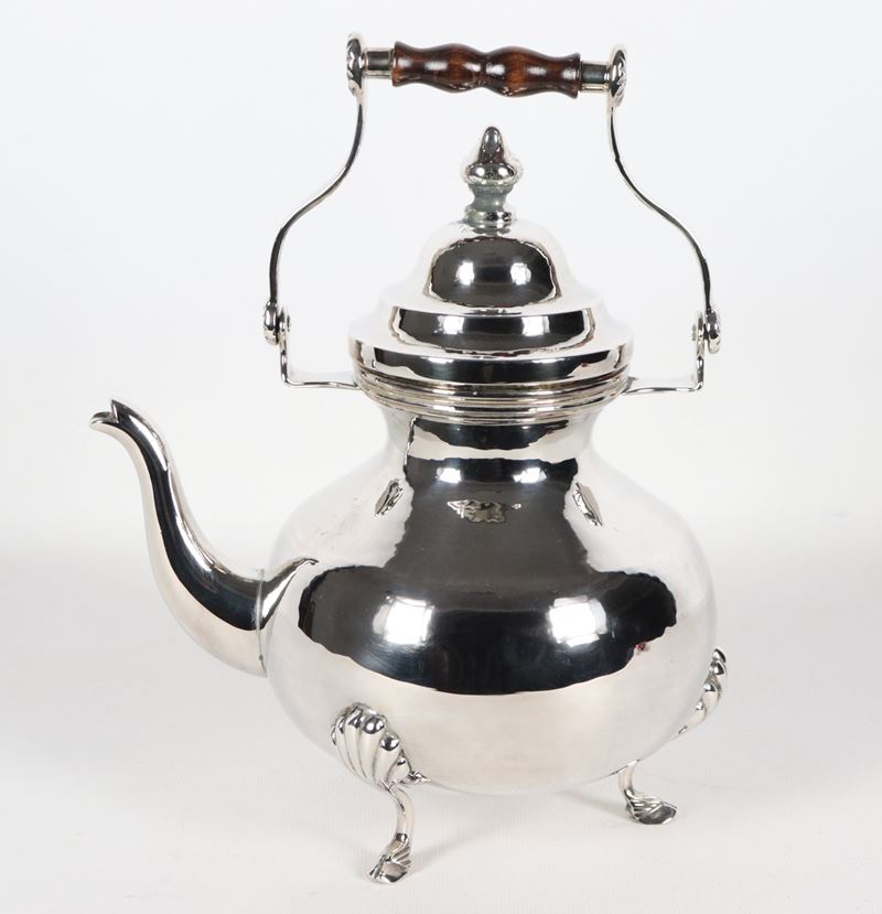Teiera in argento cesellato e sbalzato con manico alzabile, sorretta da tre piedini caprini, gr. ...