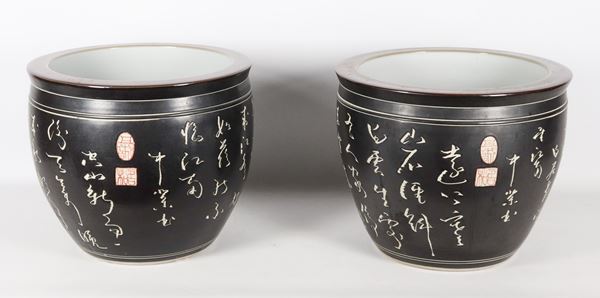 Pair of Chinese black porcelain cachepots with white inscriptions