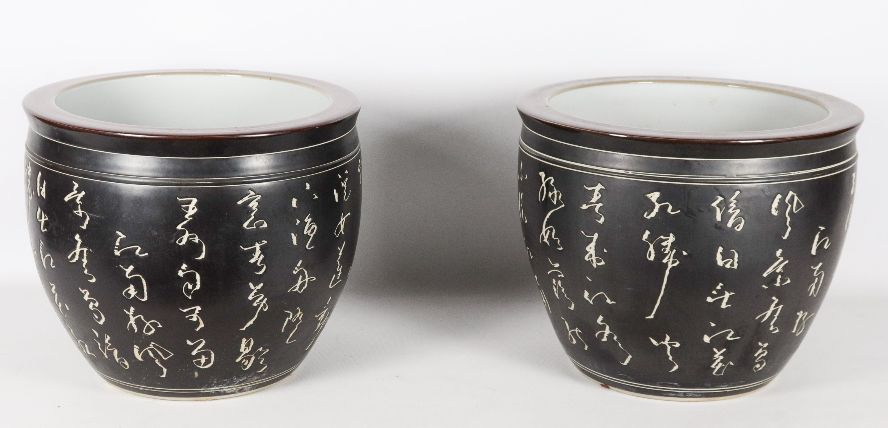 Coppia di cachepots cinesi in porcellana nera con iscrizioni in bianco