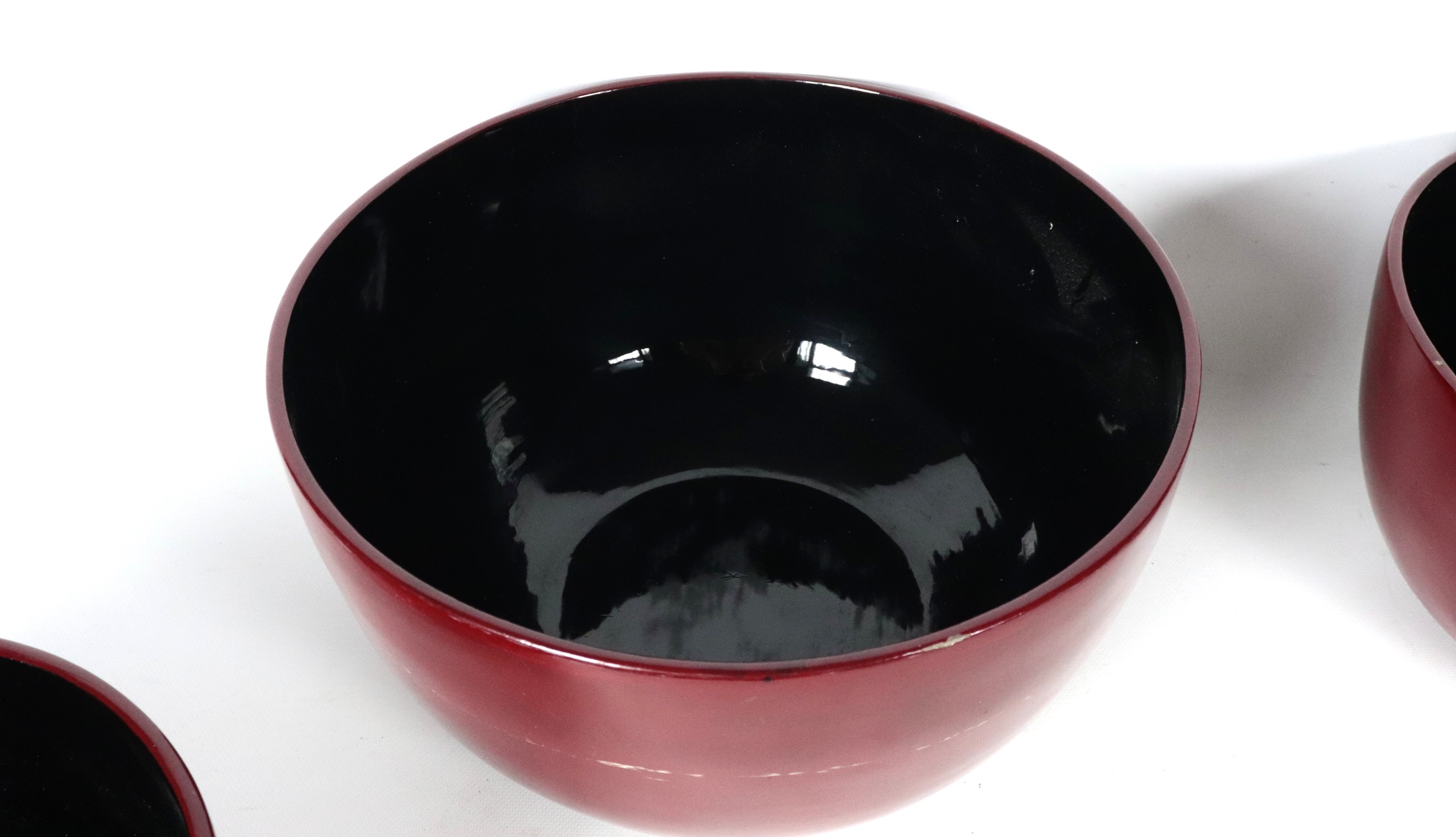 Lotto di quattro ciotole tonde di varie misure in legno laccato rosso e nero