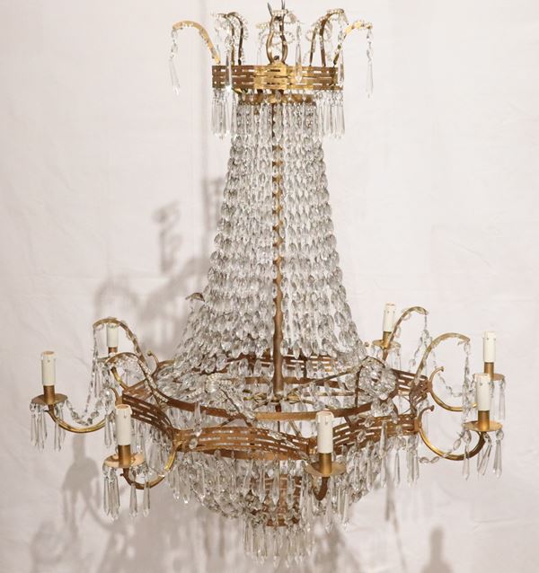 Lampadario di linea Impero in metallo dorato e cesellato con prismi, perlinature e gocce in cristallo, 8 luci