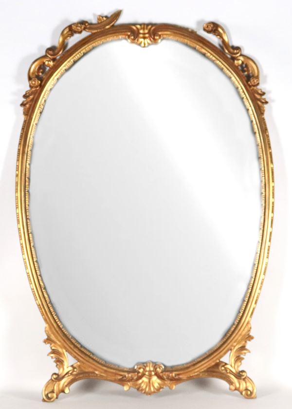 Specchiera ovale in legno dorato e intagliato