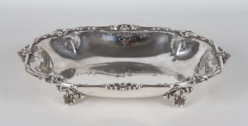 Centrotavola in argento cesellato e sbalzato con bordo traforato , sorretto da quattro piedini, g...