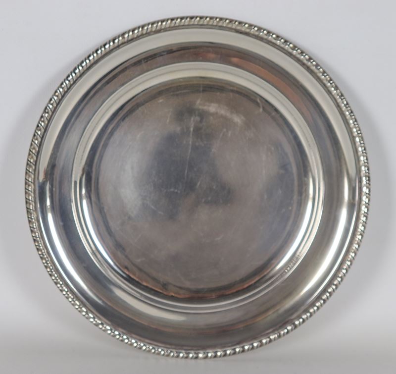 Piatto da portata in argento con bordo cesellato e sbalzato a motivi Impero, gr. 370