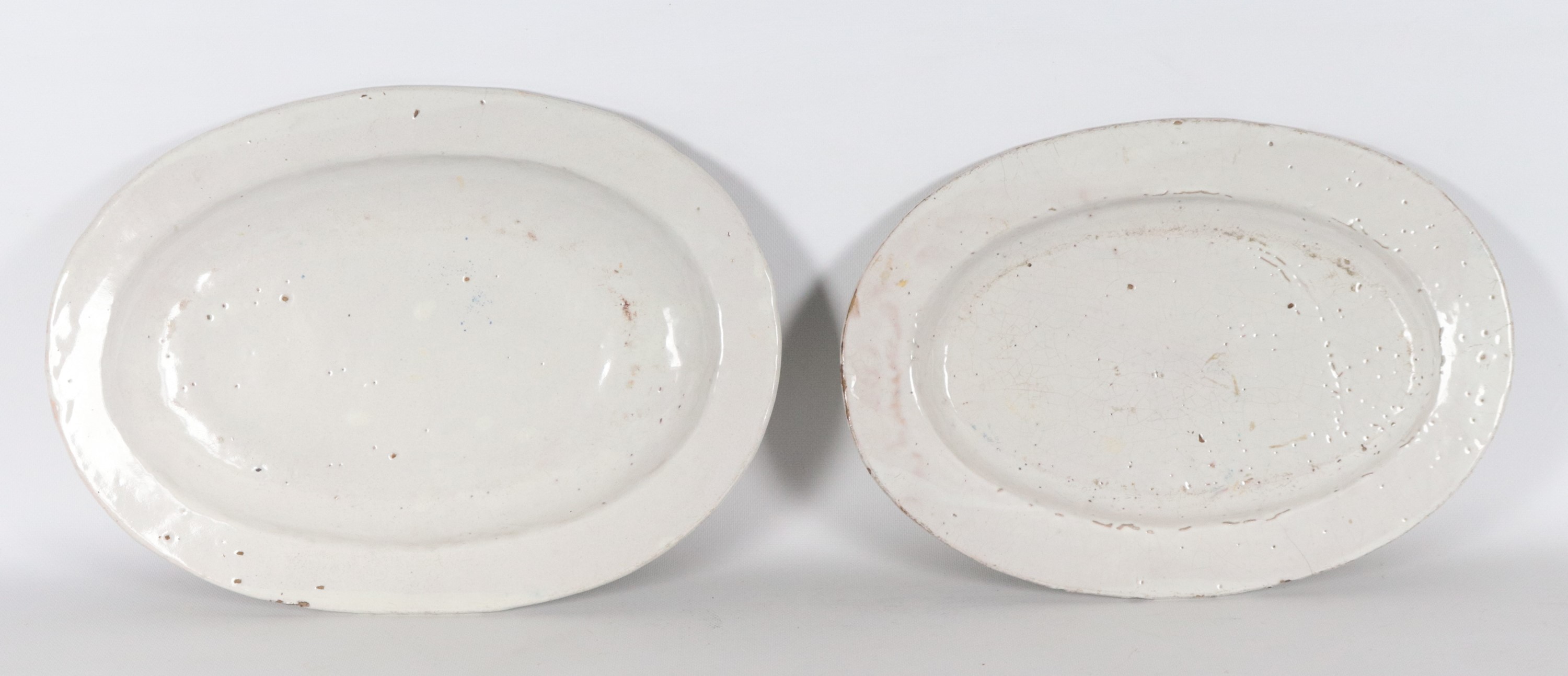 Lotto di due vassoi ovali in maiolica Deruta smaltata, decori policromi a motivi di case con torr...