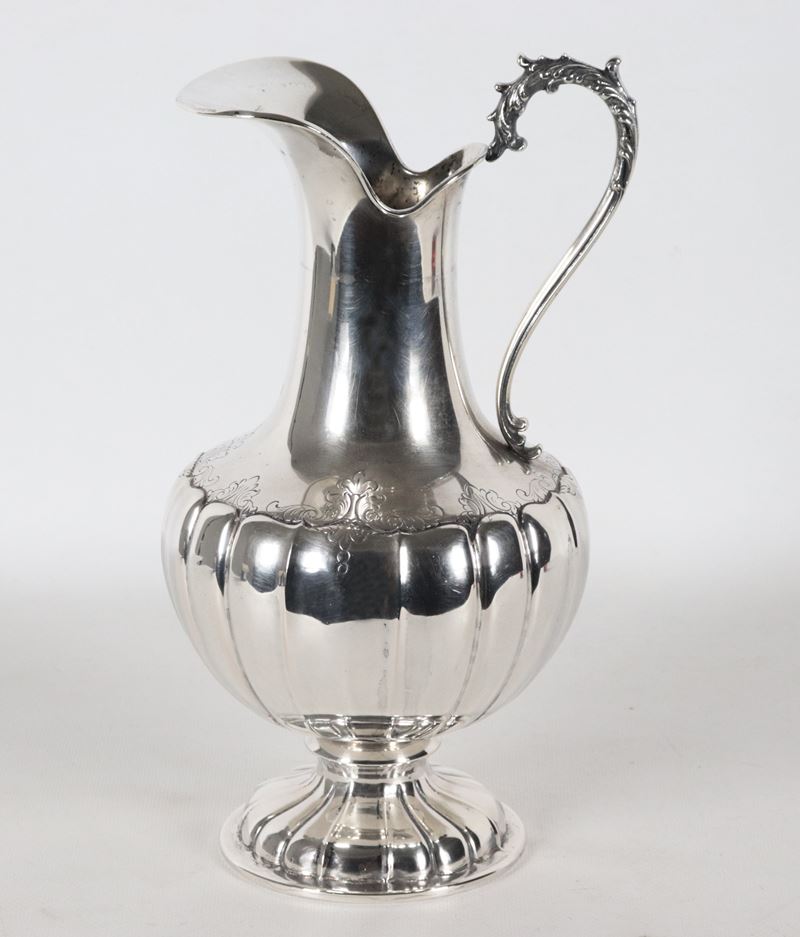 Caraffa in argento cesellato e sbalzato a baccellature, manico ricurvo. Gr. 655