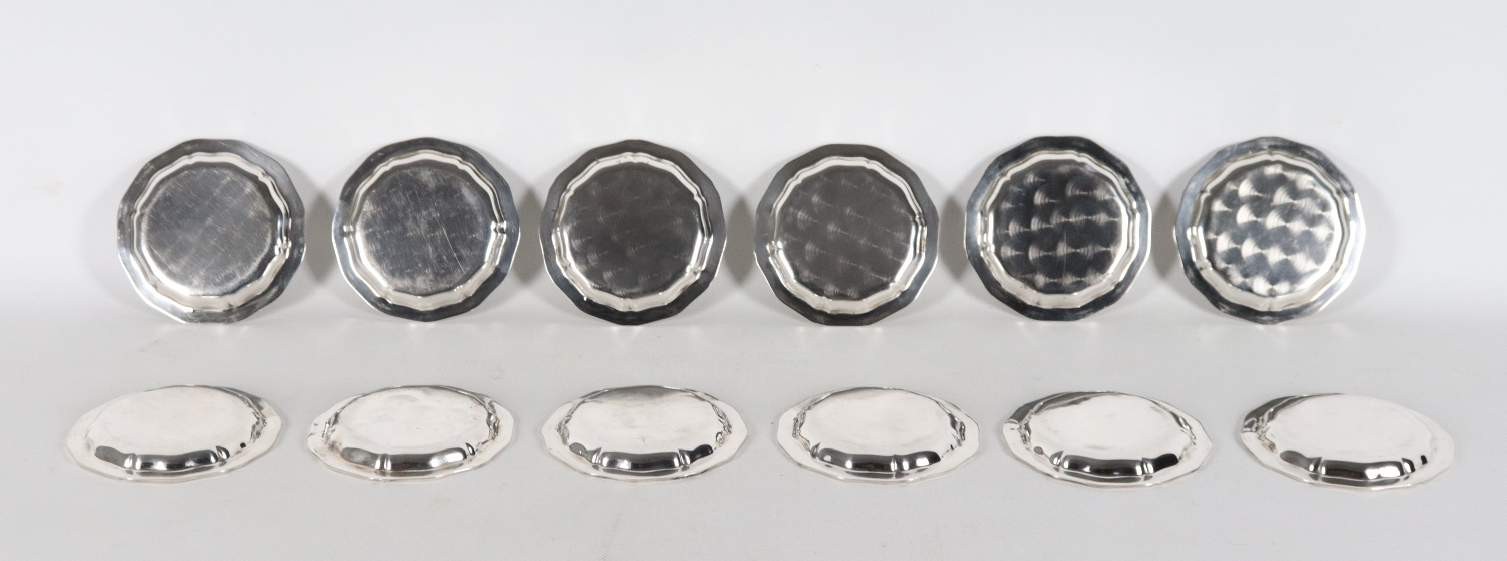 Lotto di dodici sottobicchieri in argento con bordi centinati, gr. 735