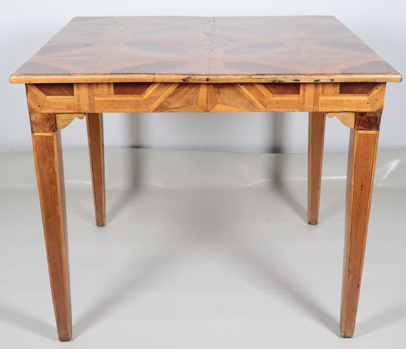 Tavolo quadrato da centro in noce, intarsiato a vari legni pregiati a motivi geometrici