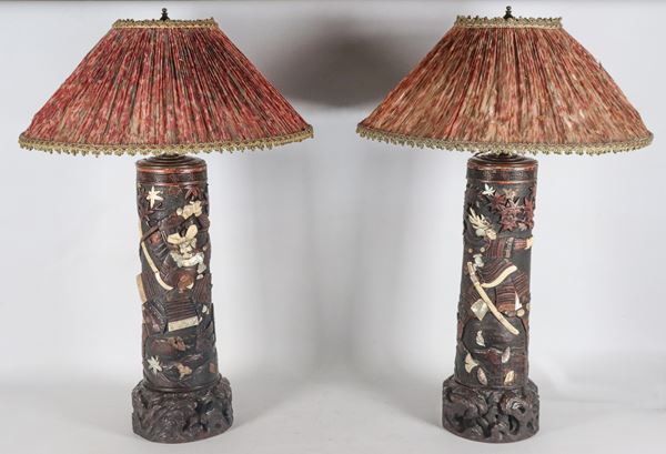 Coppia di antiche lampade cinesi in legno brunito, con intagli a rilievo di figure di Samurai