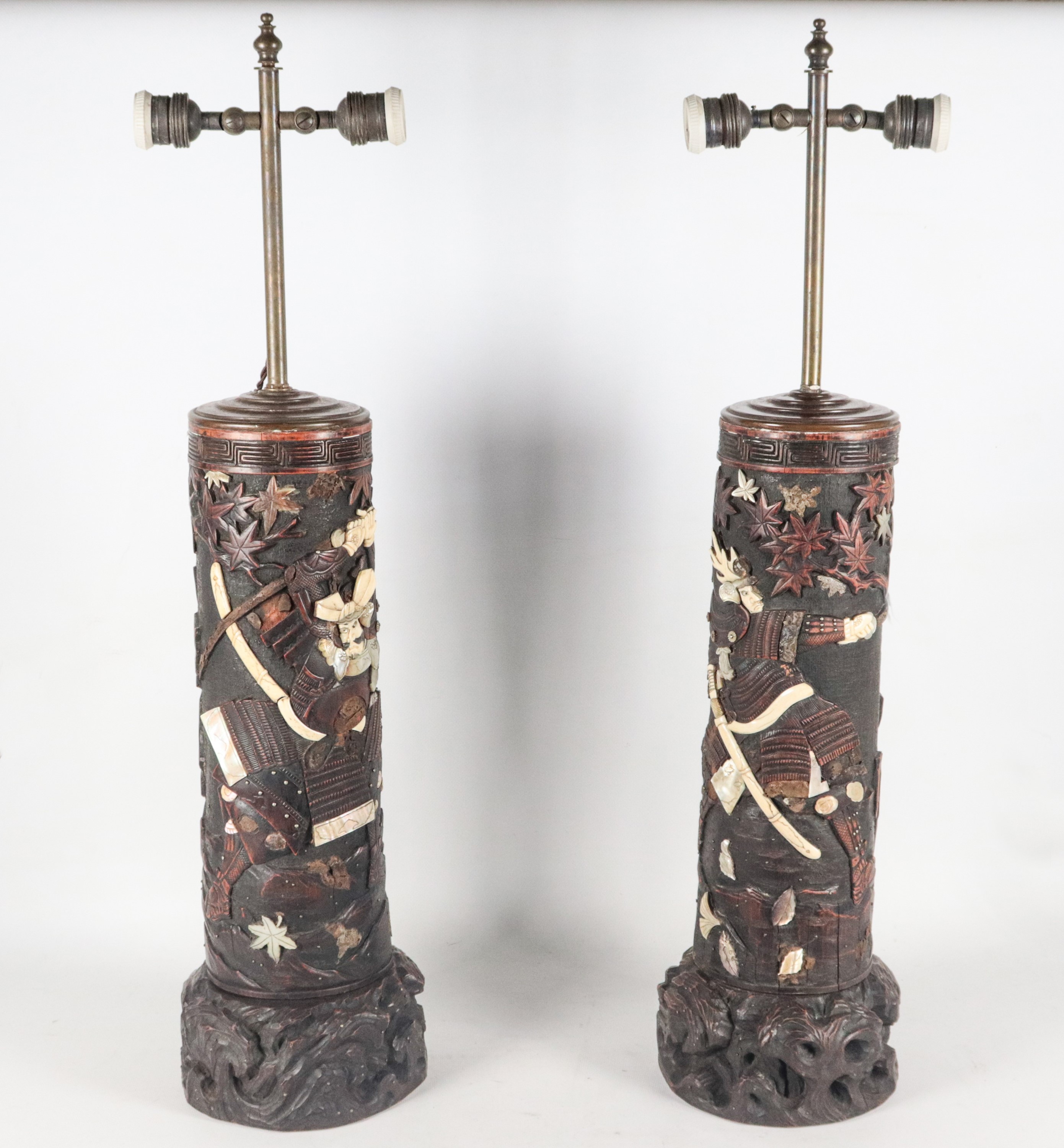 Coppia di antiche lampade cinesi in legno brunito, con intagli a rilievo di figure di Samurai