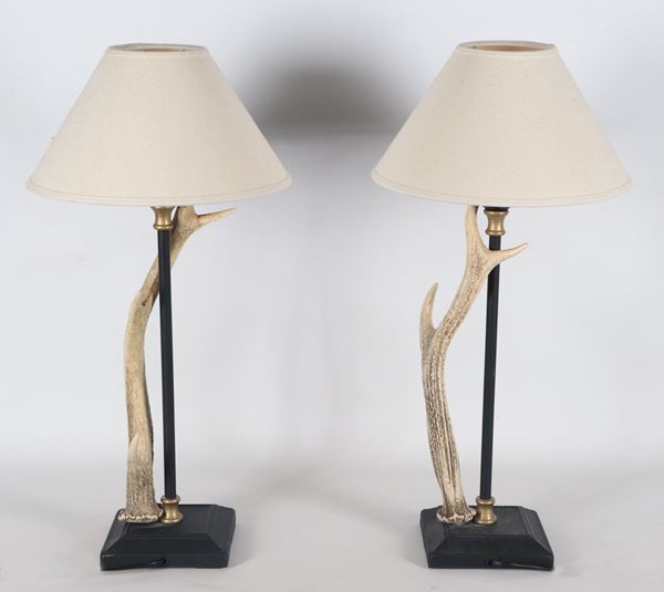 Coppia di originali lampade in metallo brunito con applicazioni di corna di cervo