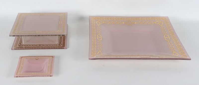 Lotto di tre originali centrotavola in vetro rosa con bordi dorati a motivi di cordoni intrecciat...