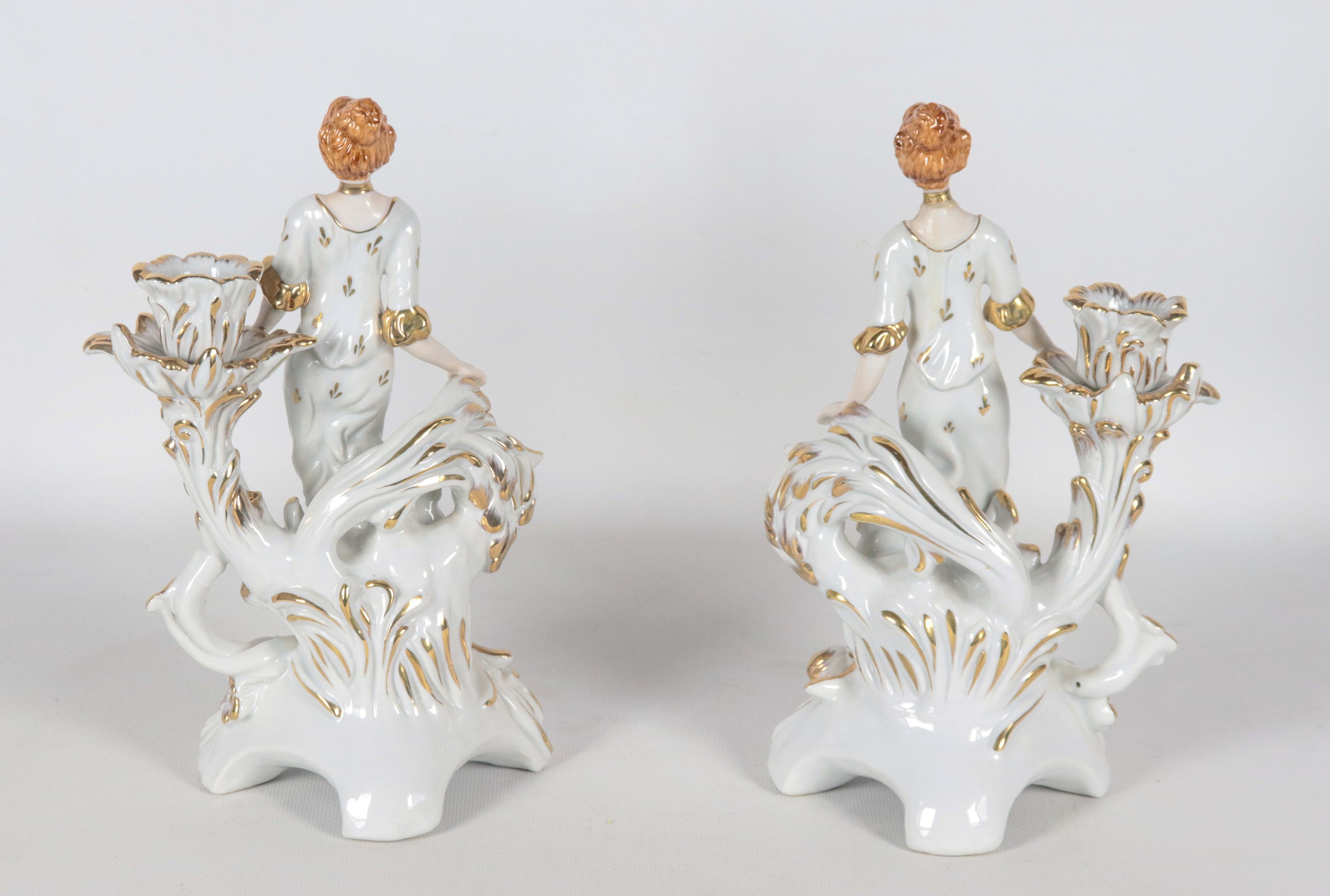 Coppia di portacandele in porcellana francese con statuine di dame, lumeggiature in oro zecchino
