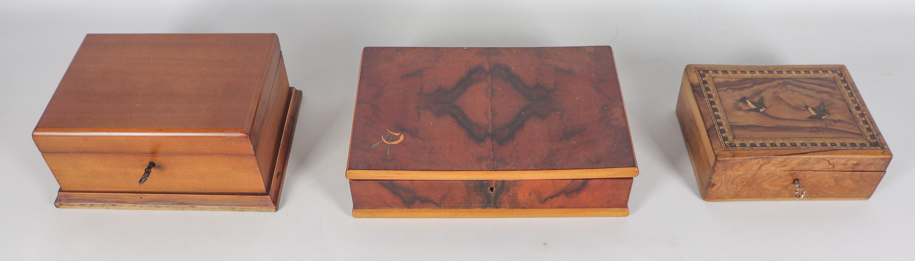 Lotto di tre scatole in noce, di cui una con intarsi sul coperchio